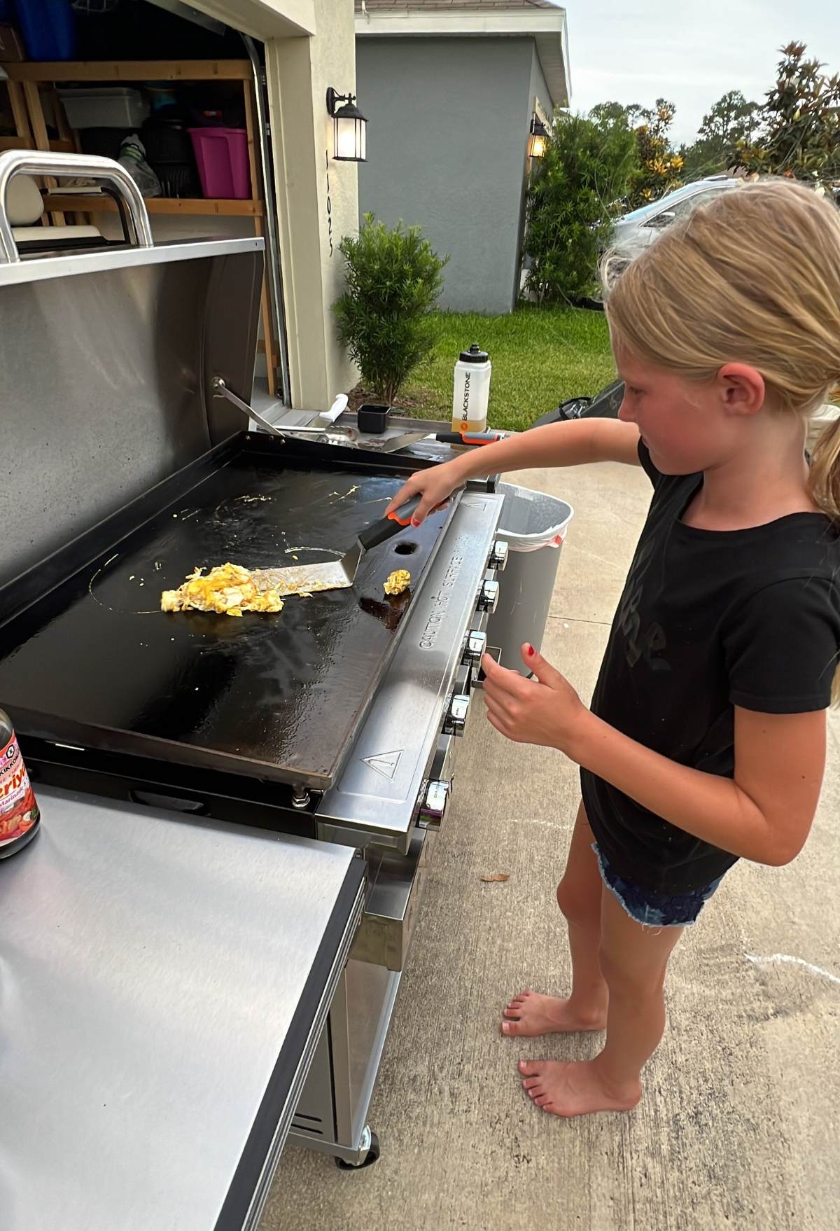 little girl frying eggs on the blackstone grill