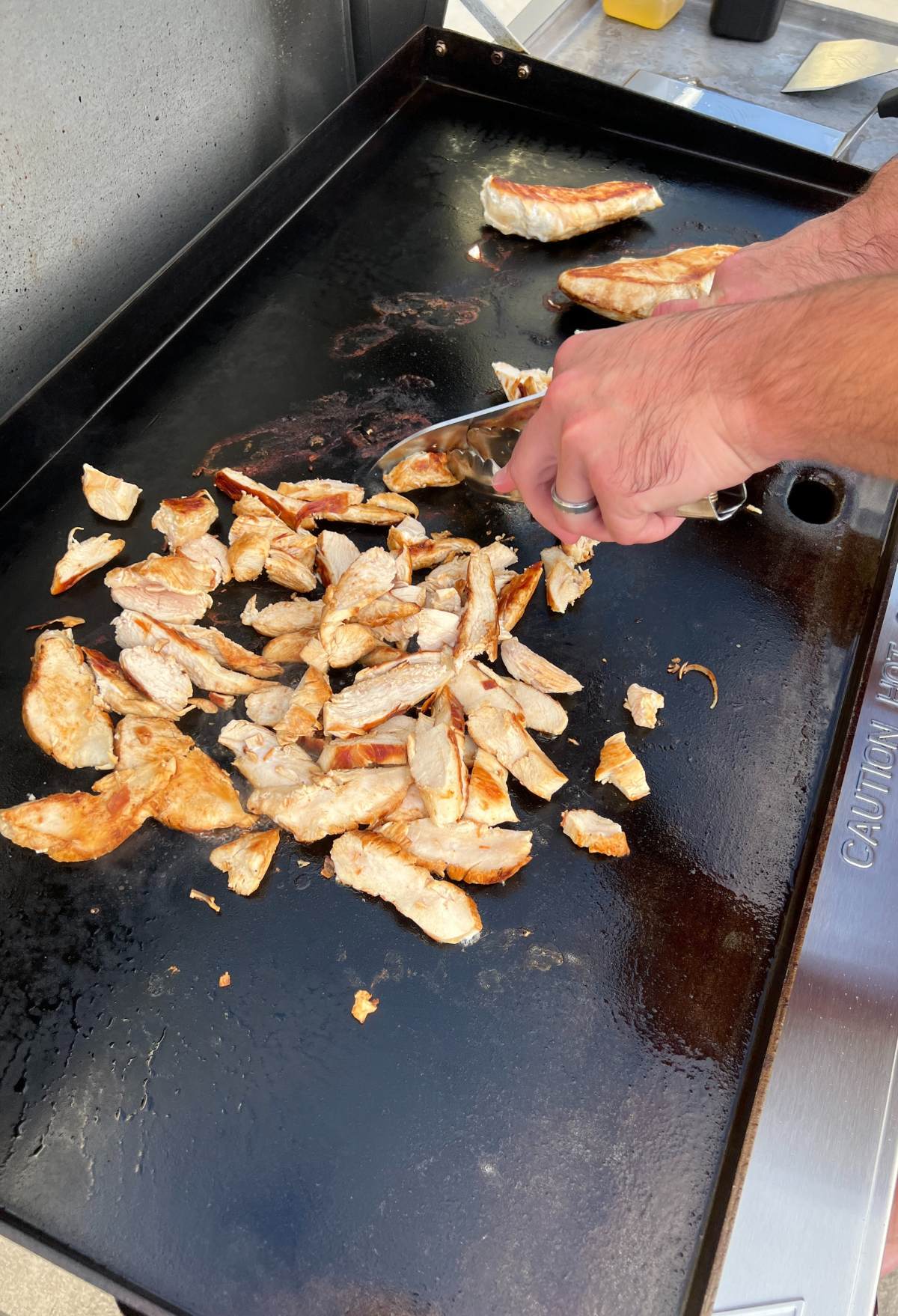 sliced chicken on the flat top blackstone griddle