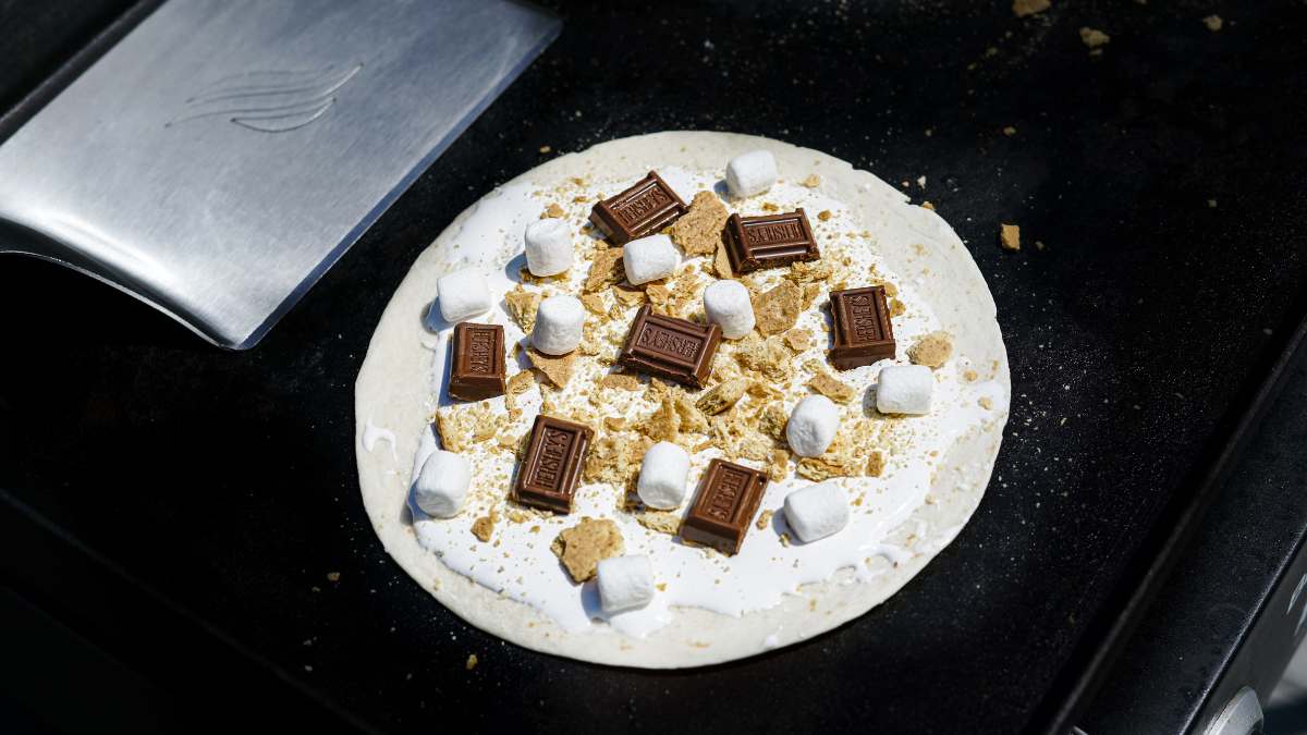 chocolate, marshmallows, and graham crackers on a tortilla shell