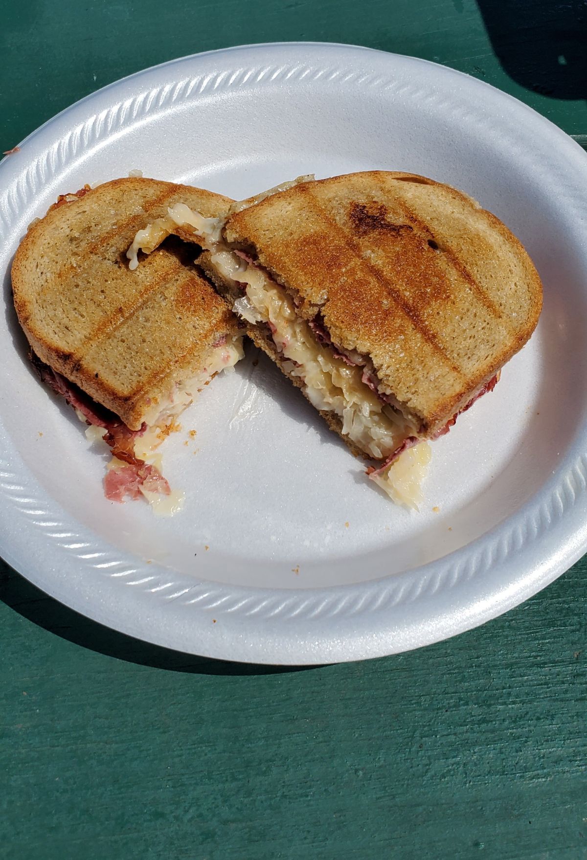 A Reuben sandwich on a paper plate.