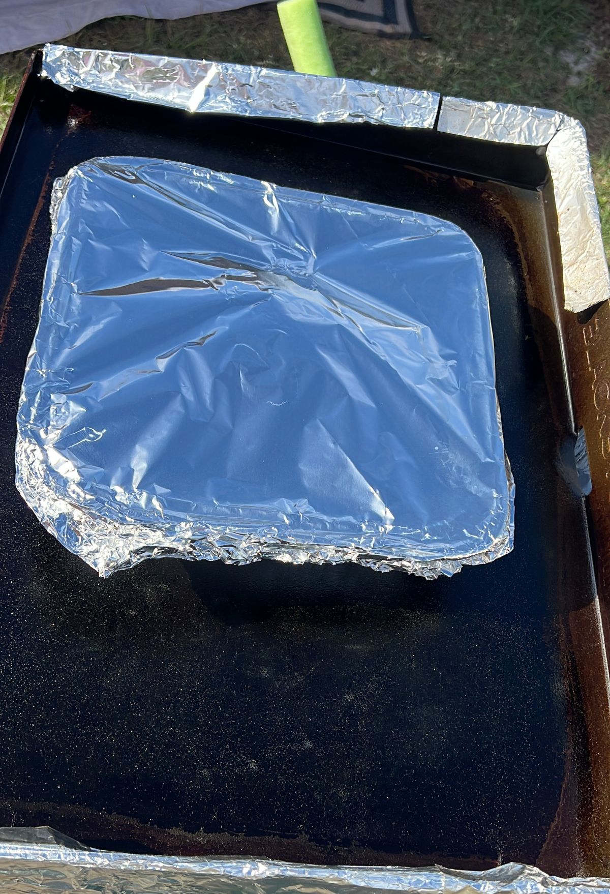 A piece of foil sitting on top of a grill.