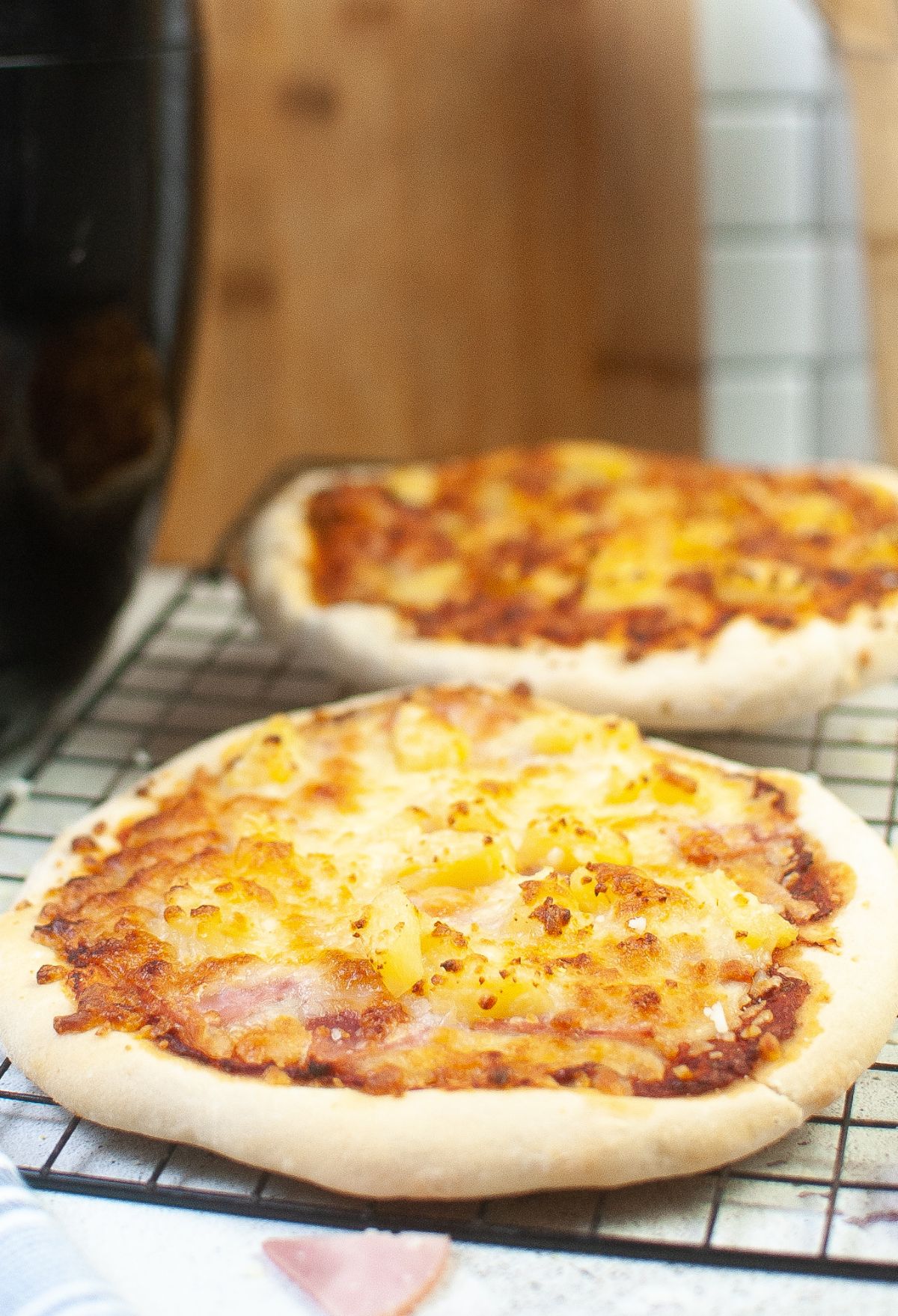 Two Blackstone pizzas on a cooling rack.
