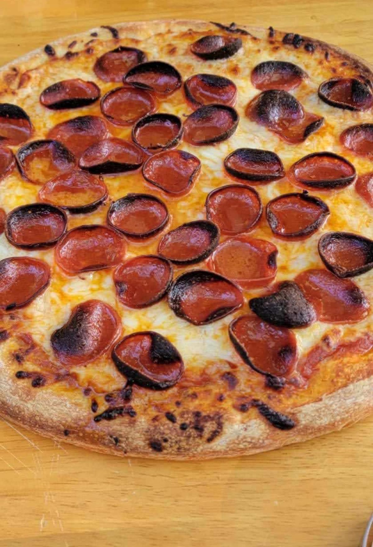 A pepperoni pizza on a wooden table.