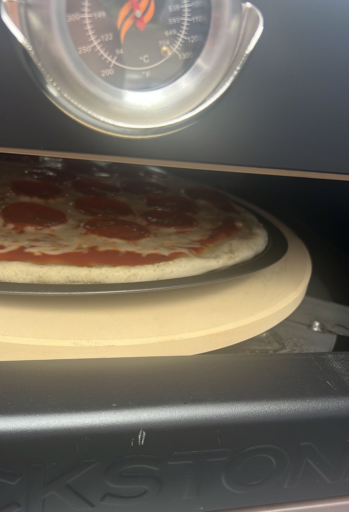 A pizza sitting in a pizza oven.