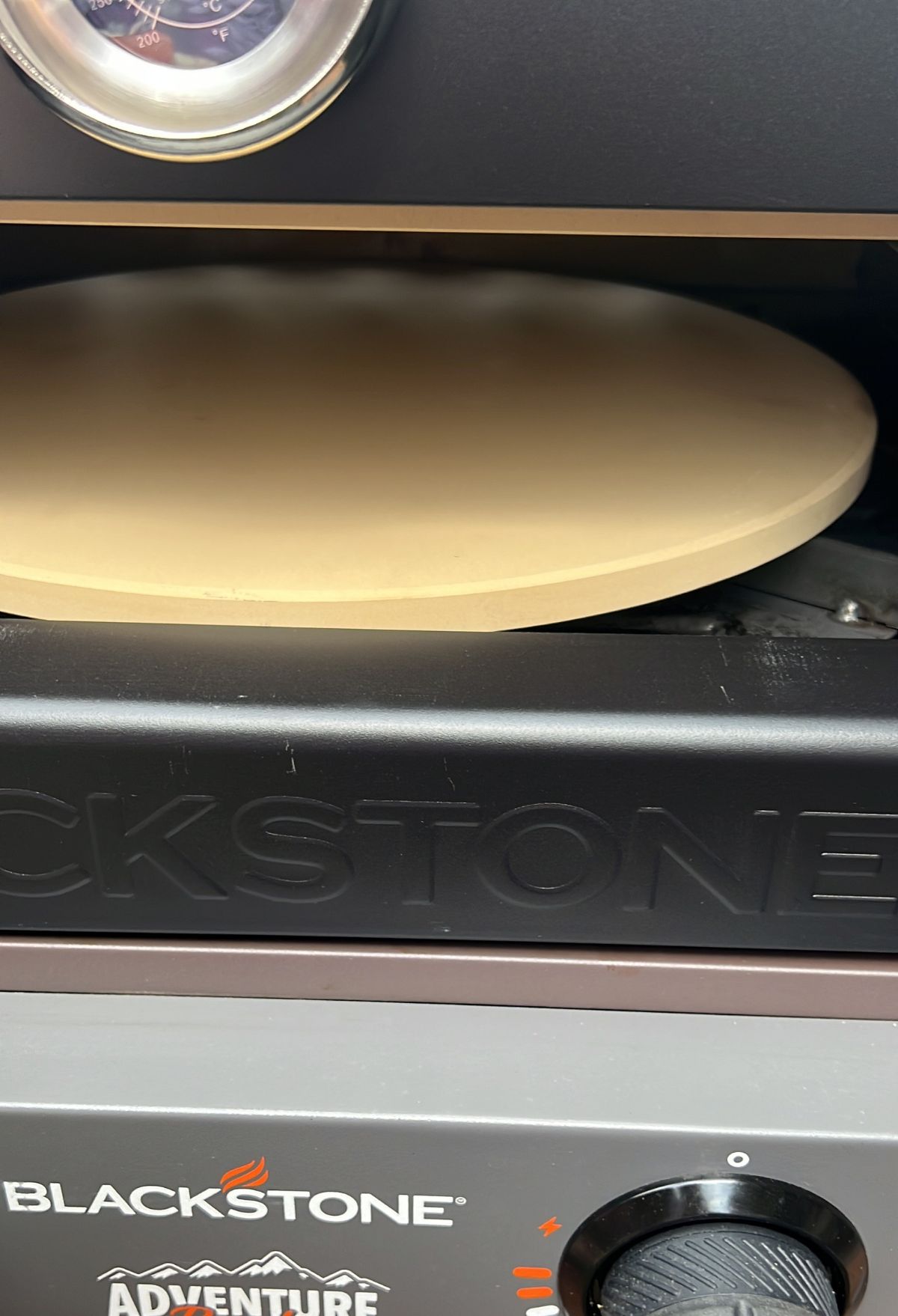 A blackstone pizza oven with a pizza on it.