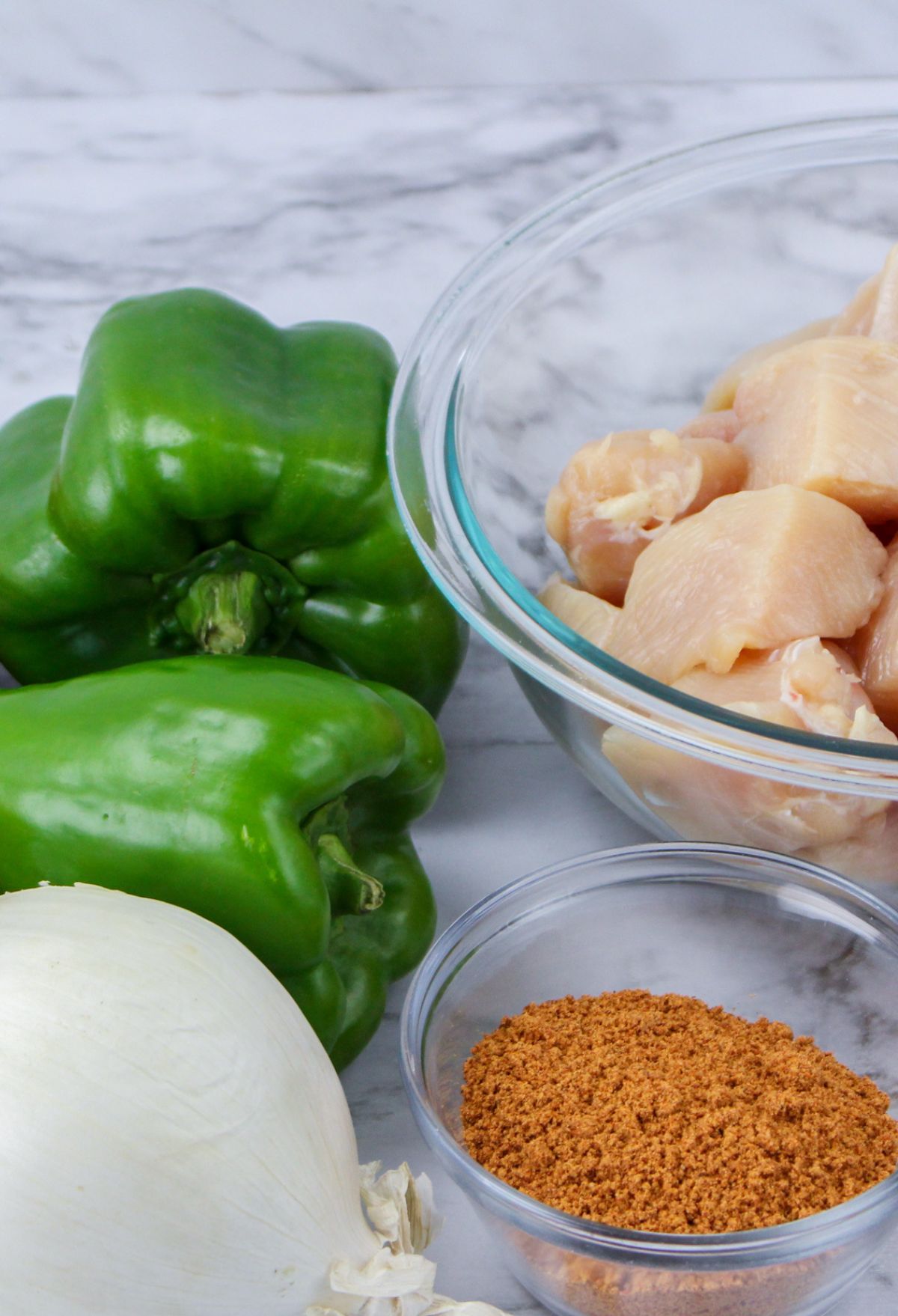 Ingredients for chicken fajitas including peppers, onions and spices.