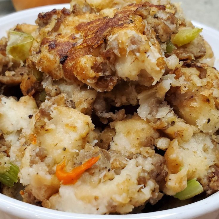 A bowl of stuffing with meat and vegetables.