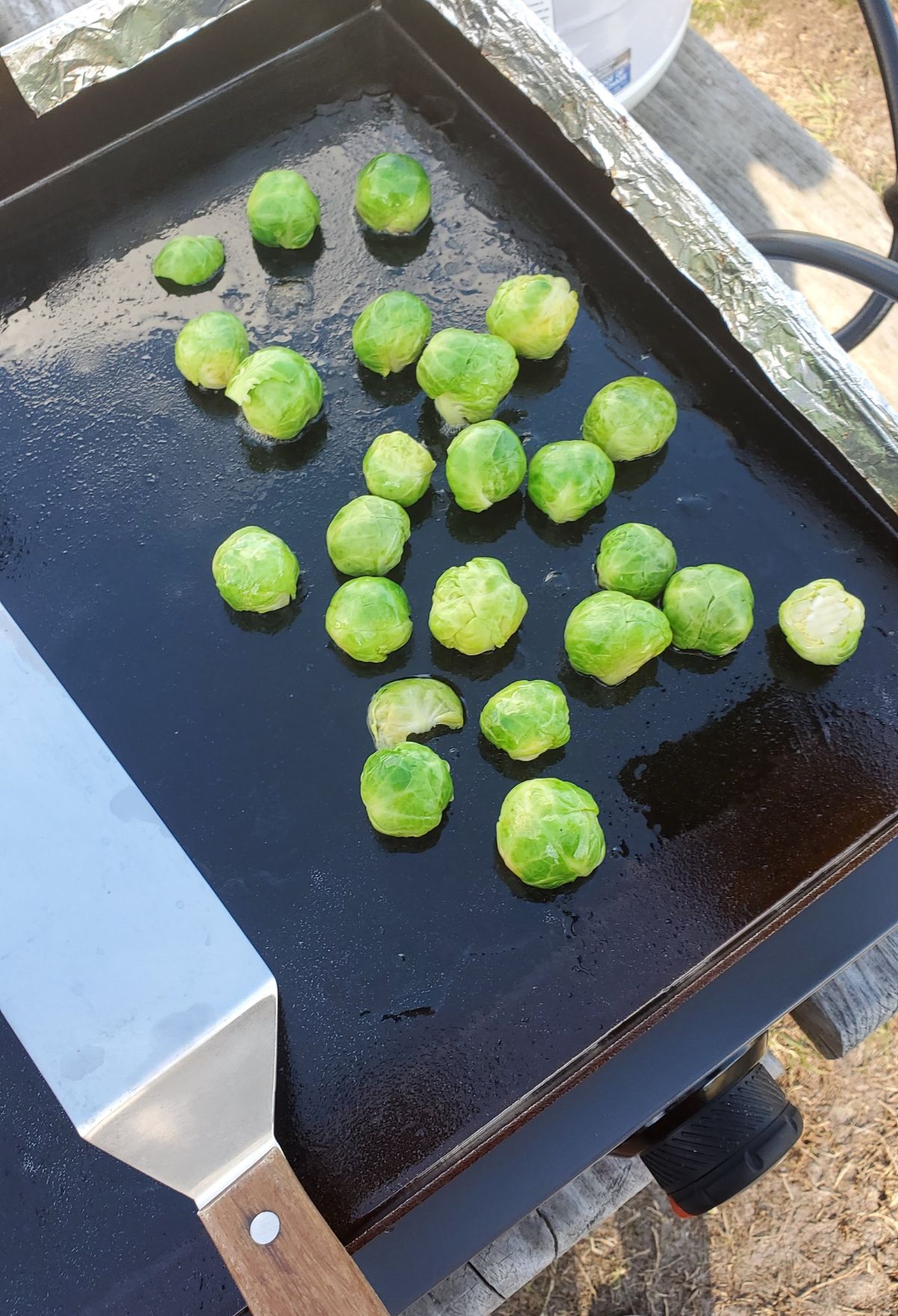 Brussel sprouts on a grill with a knife.