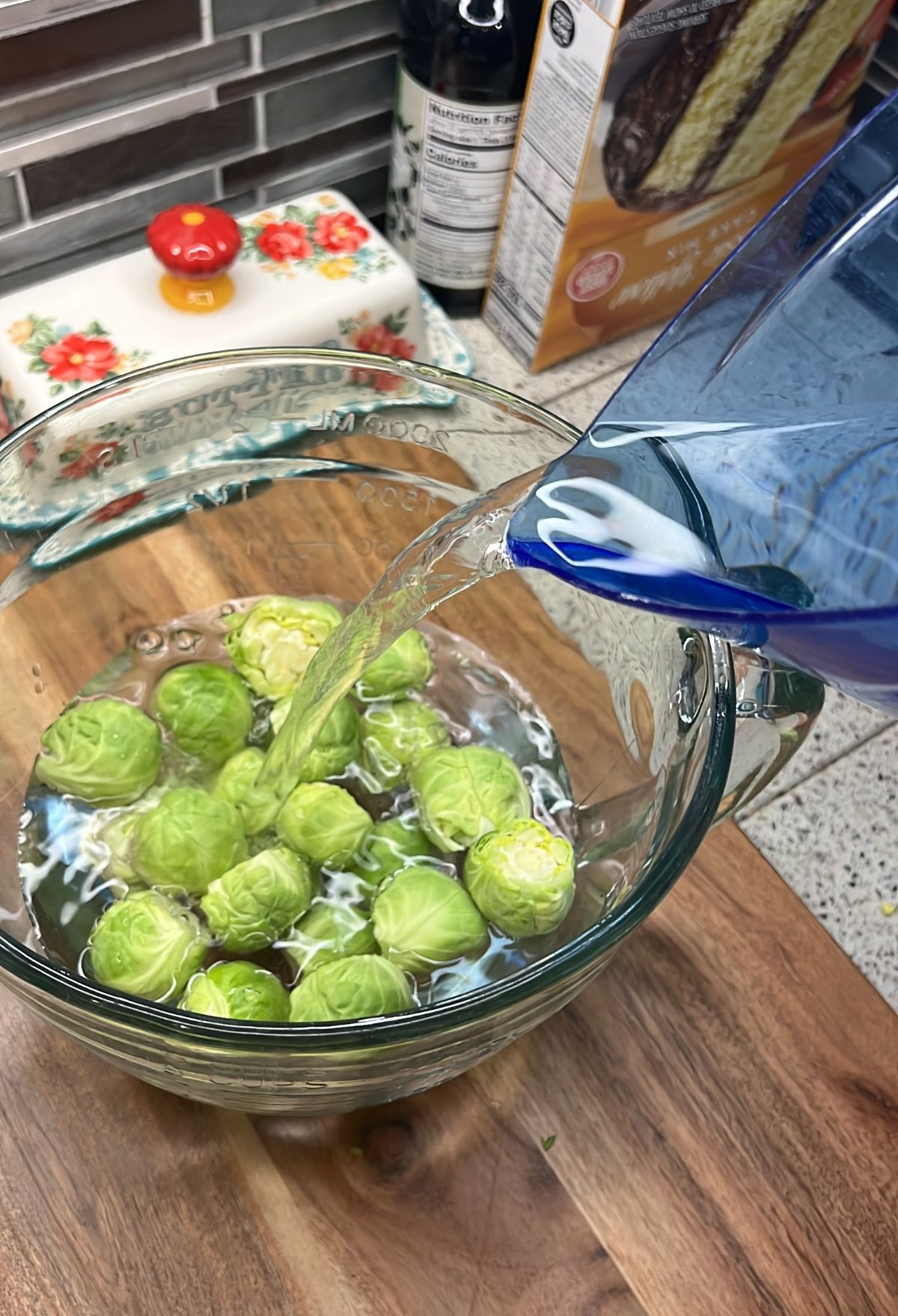 Water being poured into a bowl of brussels sprouts.