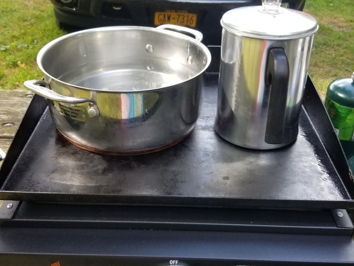 A pot and a pan on a camp stove.