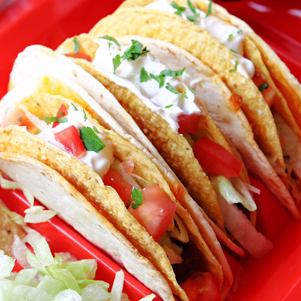 Three Cheesy Gordita Crunch tacos on a red tray.
