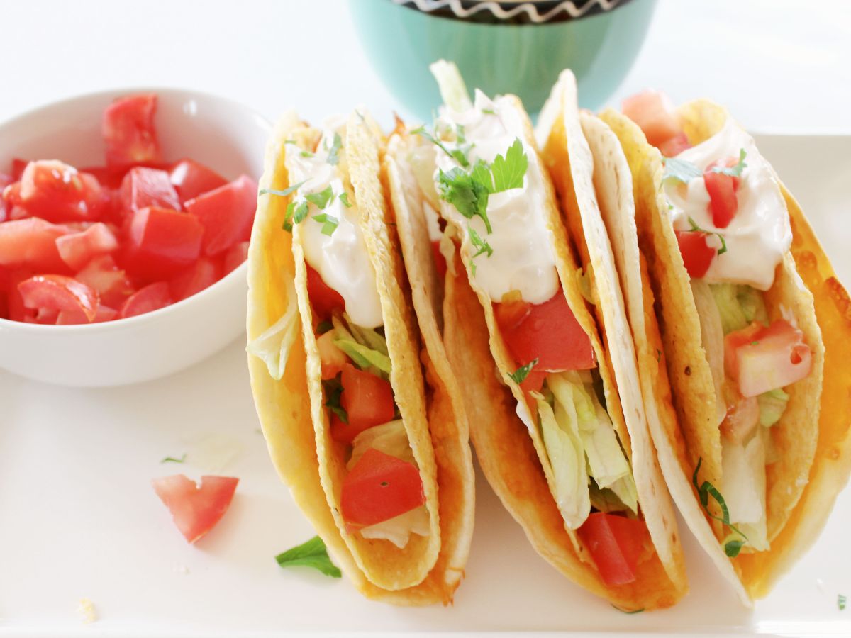 Three tacos are sitting on a white plate. Blackstone Taco Bell Cheesy Gordita Crunch Copycat