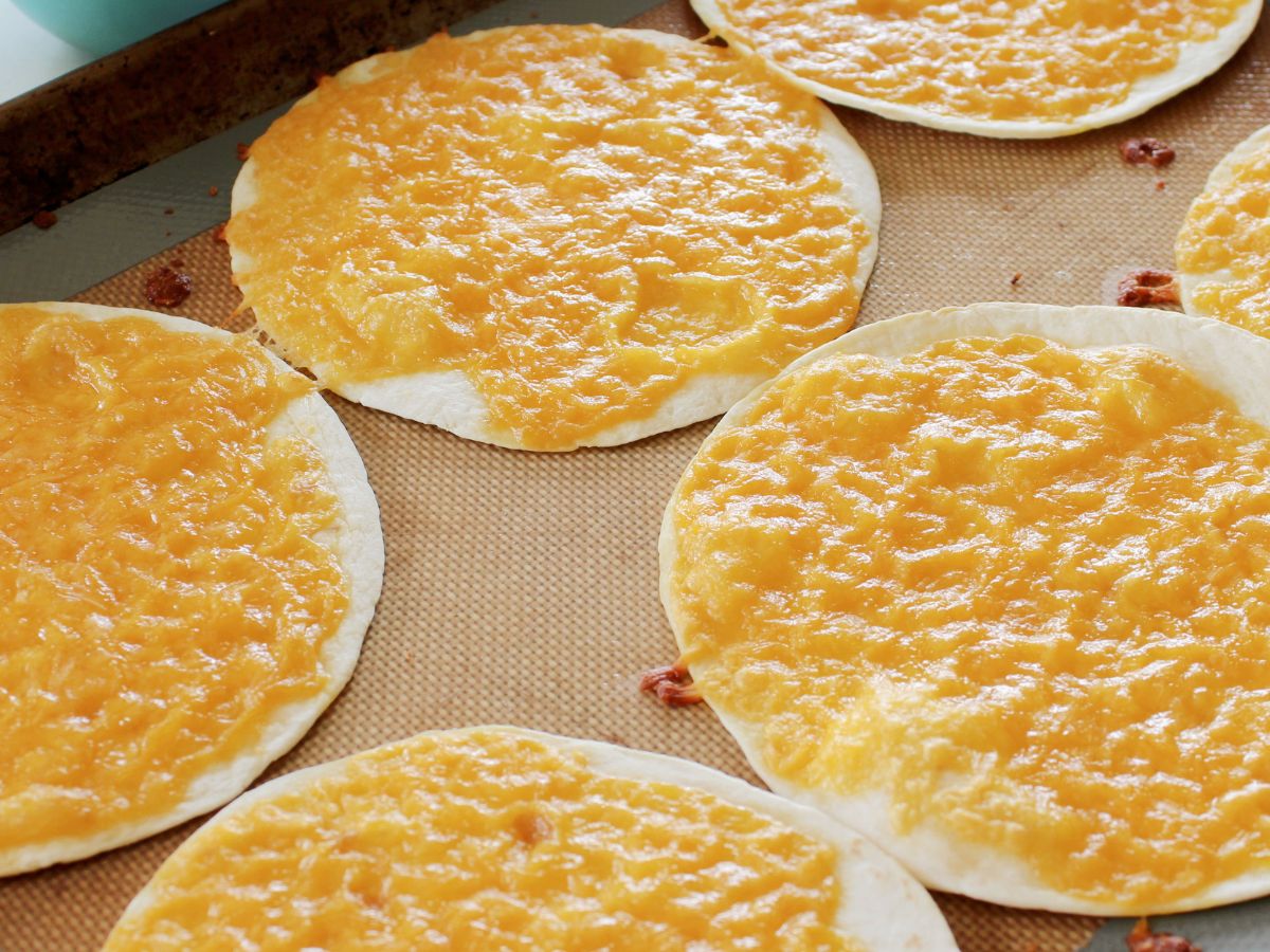 Cheesy quesadillas on a baking sheet.