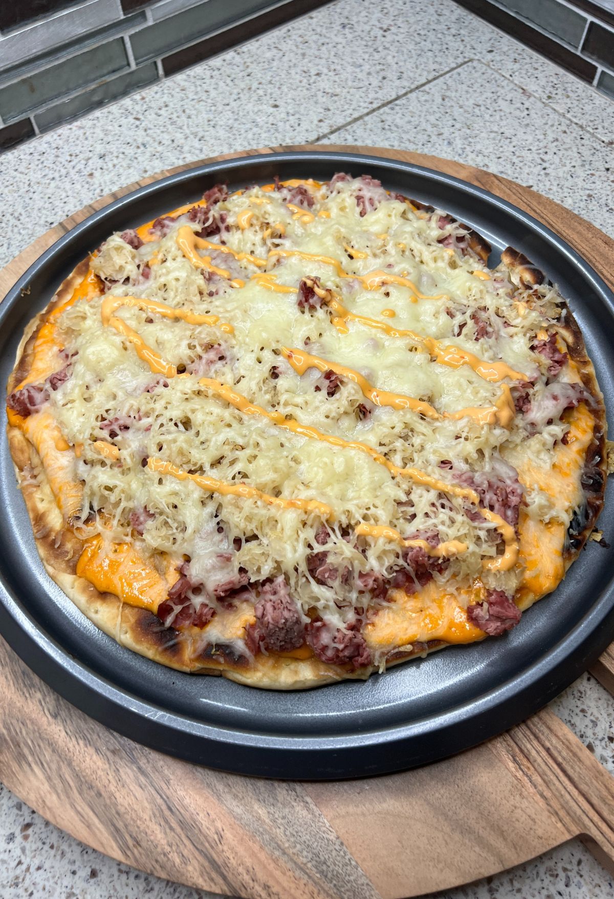 A pizza on a pan with cheese on it.