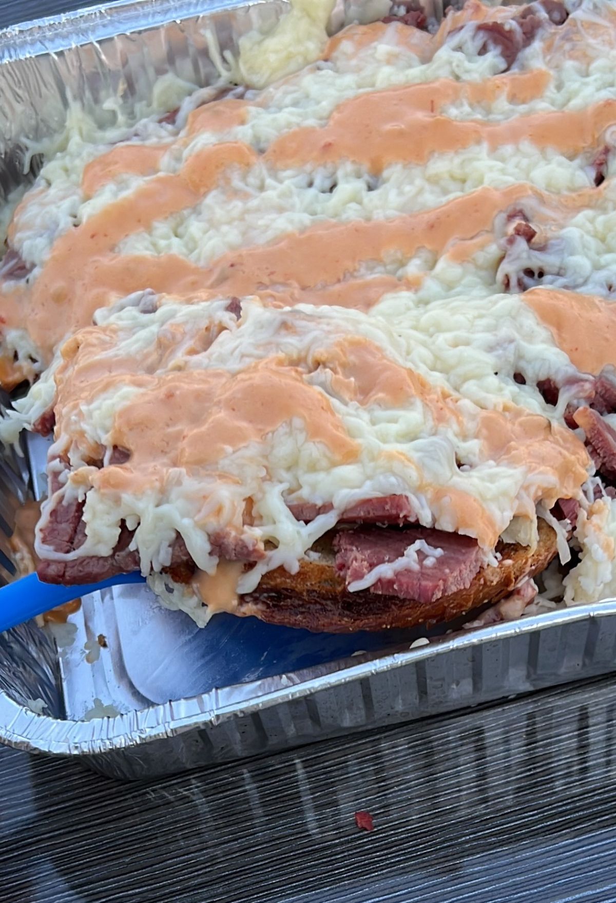 A Reuben Casserole, made with cheese, meat, and served in a pan on a table.