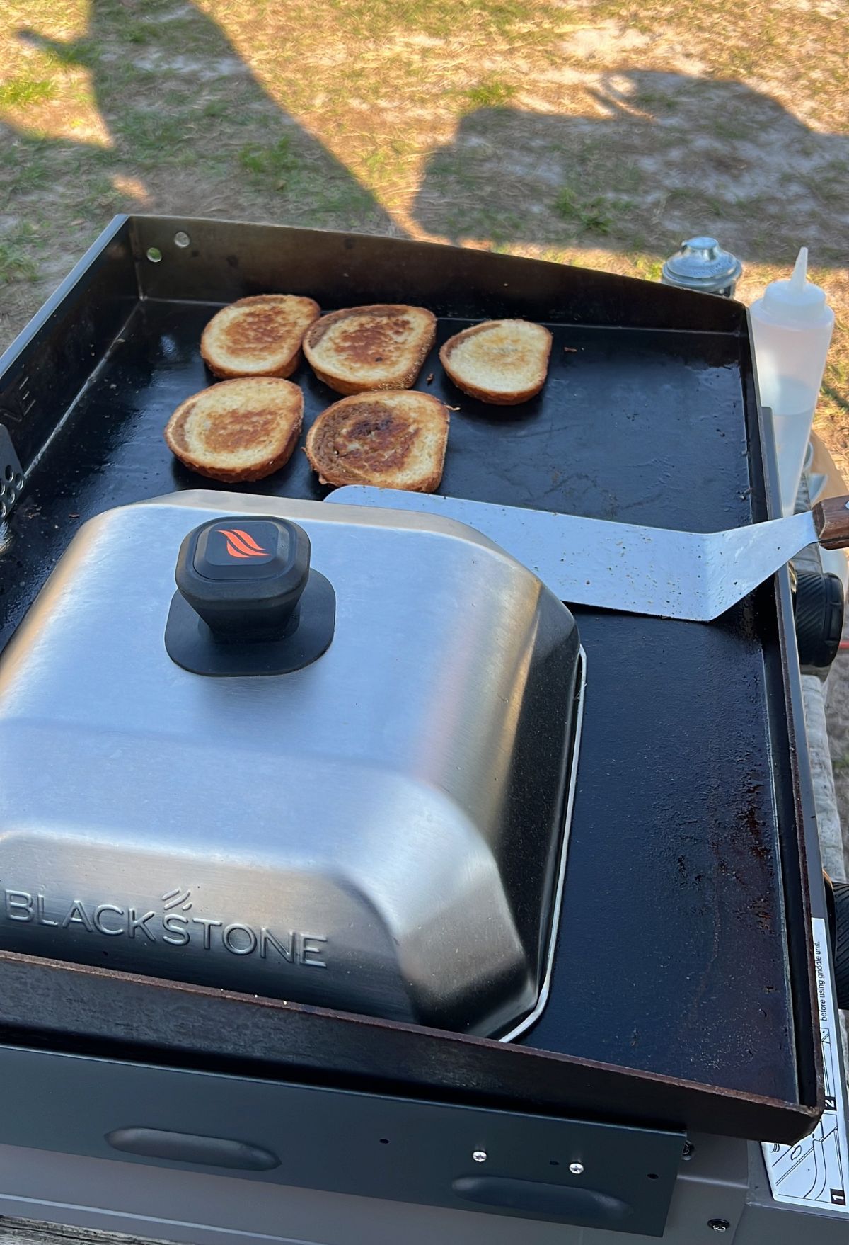 A grill with food on it and a knife on it.