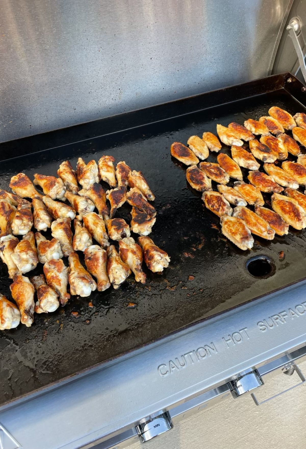 A group of chicken legs on a grill.